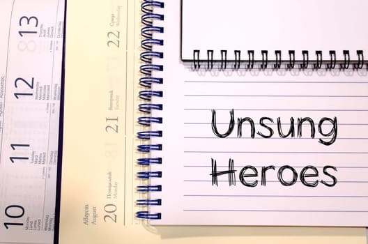 Unsung heroes text concept write on notebook
