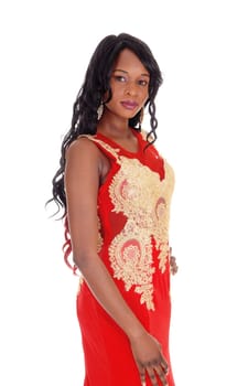 A gorgeous African American woman standing in a red evening dress.with gold embroideries and long black hair isolated for white background..