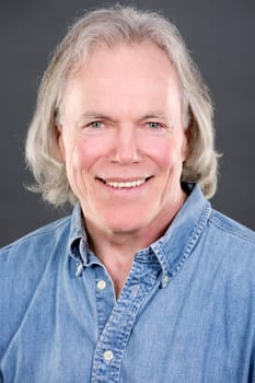 handsome caucasian man wearing blue shirt on grey background