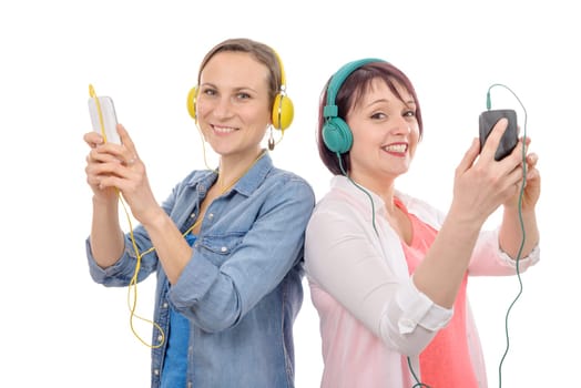 Two beautiful women listening to music with smartphone and headphones isolated on white background