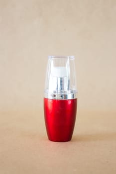 Shiny hard red bottle on brown background, stock photo