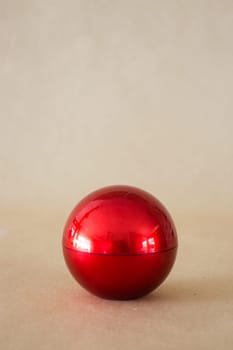 Shiny hard red ball on brown background, stock phoro