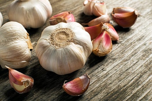 Garlic cloves on wooden background close up.