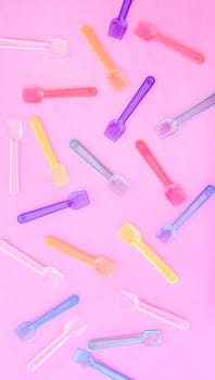 Small colorful ice lolall scattered on pink
