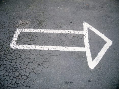 An arrow outline painted by hand on the asphalt to the right.