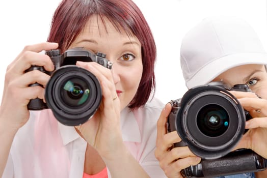 Two beautiful young women using a camera on hwhite background