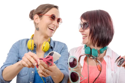 two pretty women trying on sunglasses, isolated on white