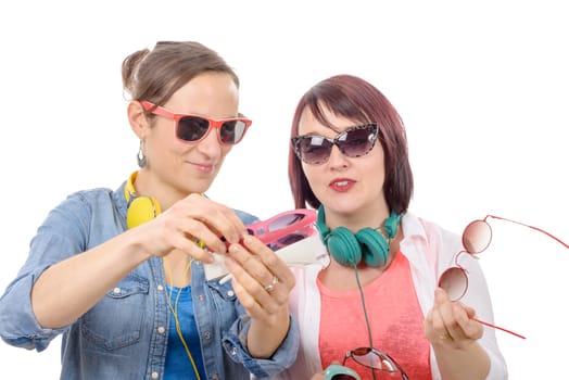 two pretty women trying on sunglasses, isolated on white