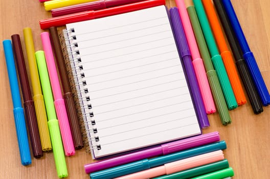 Felt-tip pen and notepad on a wooden background