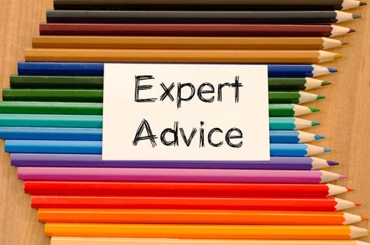 Expert advice text concept and colored pencil on wooden background