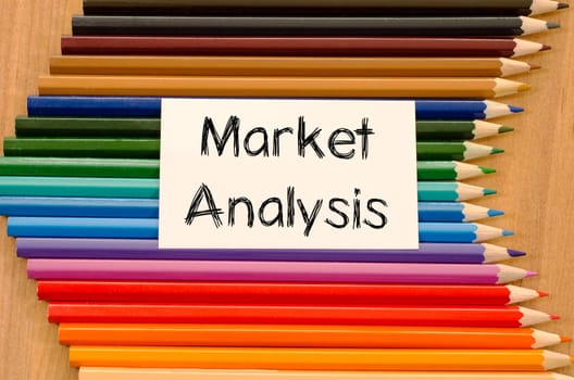 Market analysis text concept and colored pencil on wooden background