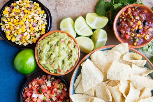 Tortilla chips served with guacamole, salsa, and pico de gallo, view from above.