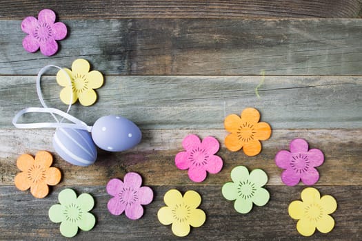Easter Eggs and wooden flowers on wooden table with copy space.