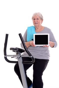 gray-haired female senior train with fitness machine and showing tablet PC