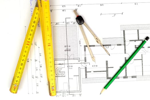 building plan with pencil,folding yardstick and compass on wooden table