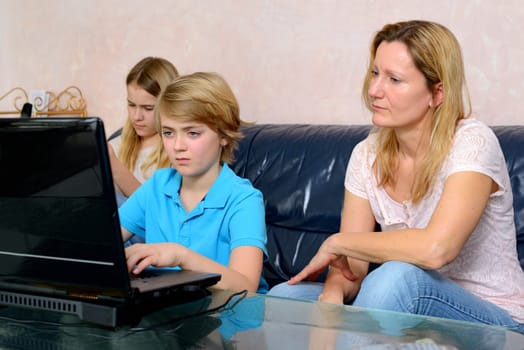 blonde mother and her children using computer together