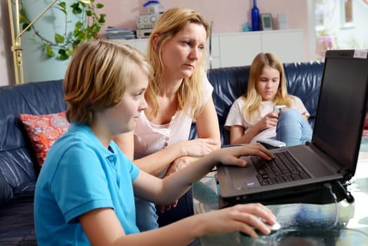 blonde mother and her children using computer together