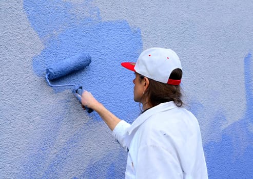 workman painting the wall with paint roller