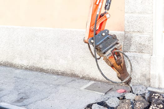 Large pneumatic hammer mounted on the hydraulic arm of a construction equipment