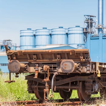 Railway wagon freight,with a factory in the background