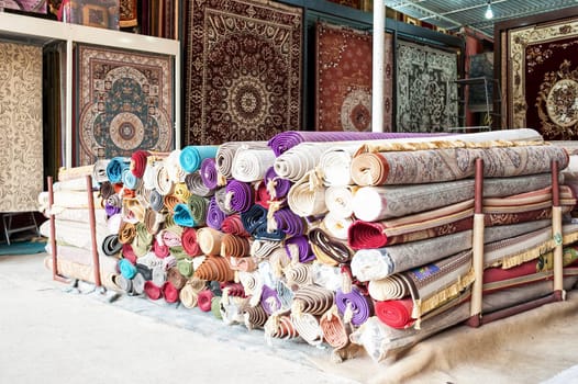 Many colorful carpets for sale in the store.