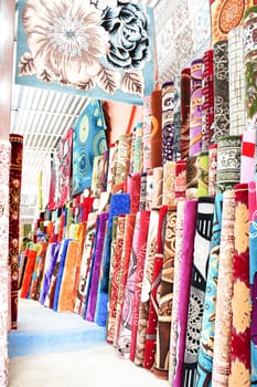 Many colorful carpets for sale in the store.