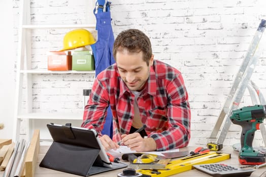 a smilling young man using the tablet for DIY