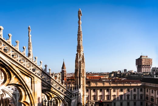 White marble statues on the roof of famous Cathedral Duomo di Milano on piazza in Milan, Italy
