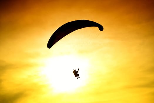 Silhouette of parachute on sunset background