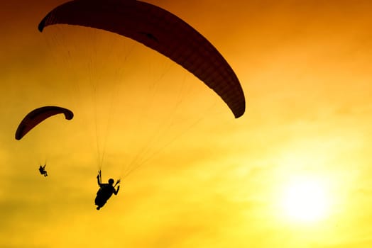 Silhouette of parachute on sunset background