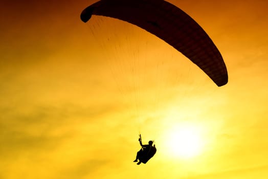 Silhouette of parachute on sunset background