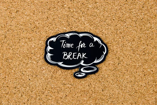 Time For A Break written on black thinking bubble over cork board background, copy space available