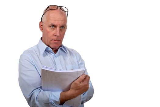 Man standing in blue shirt with a notebook in hands