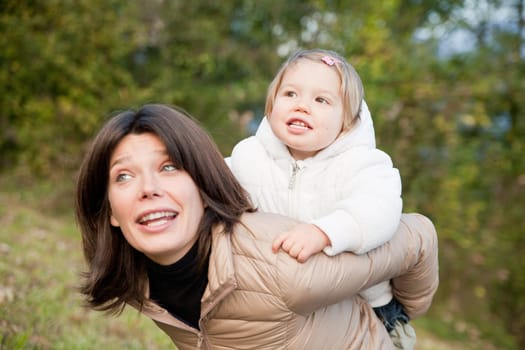 piggyback ride of little daughter on her mother