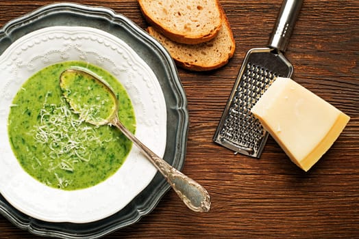 Fresh green soup on wooden background overhead shoot.