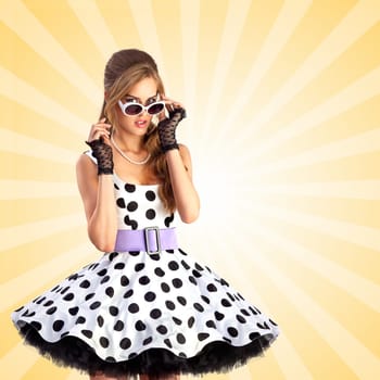Creative photo of a vogue pin-up girl, dressed in a retro polka-dot dress and sunglasses, posing on colorful abstract cartoon style background.