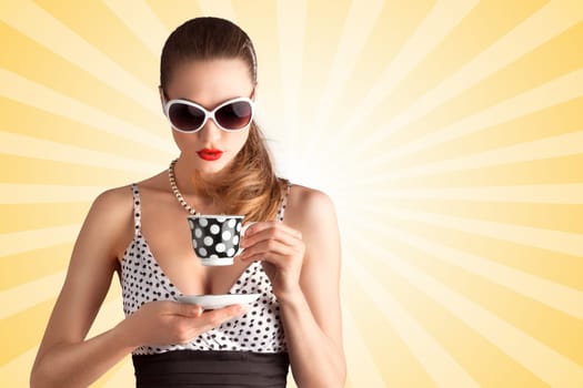 Creative vintage photo of a beautiful pin-up girl in a polka dot bikini and sunglasses, drinking tea or coffee on colorful abstract cartoon style background.