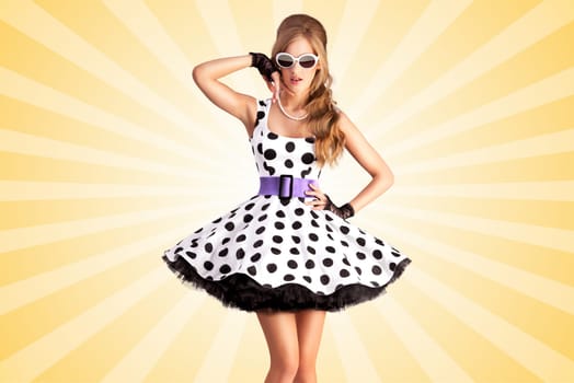 Creative photo of a vogue pin-up girl, dressed in a retro polka-dot dress and sunglasses, posing on colorful abstract cartoon style background.
