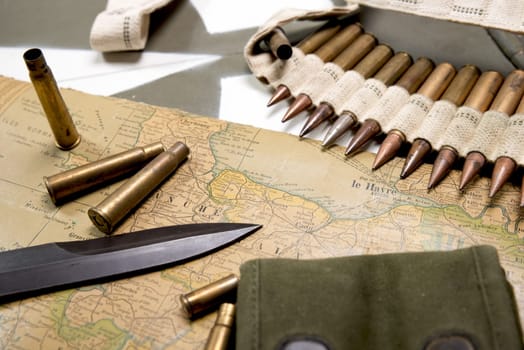 map of Normandy placed on the hood of military vehicle with weapons