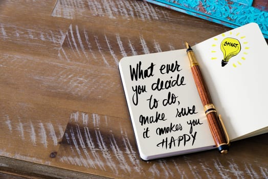 Handwritten text What ever you decide to do, make sure it makes you happy with fountain pen on notebook. Concept image with copy space available.