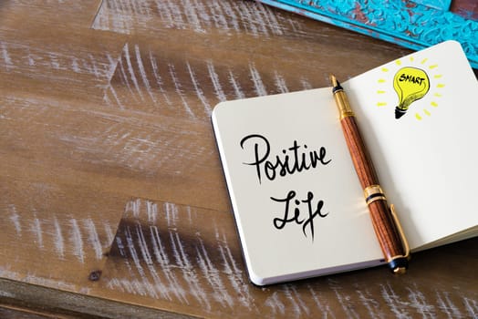 Handwritten text Positive Life with fountain pen on notebook. Concept image with copy space available.