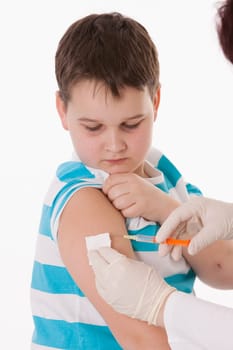 Doctor giving a child injection in arm on isolated image.