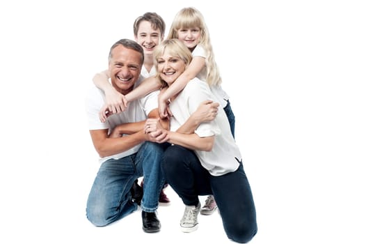 Parents giving piggyback ride to their son and daughter.
