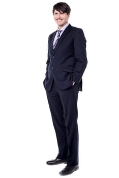 Confident modern businessman keeping his hands in trousers pockets
