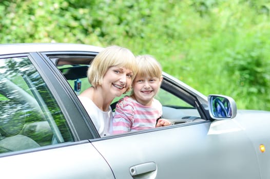 Family vacation. Mom with her child in car trip.