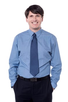 Elegant business man with hands in pockets looking at camera.