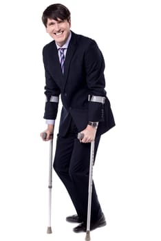 Businessman with crutch isolated on white background.