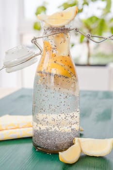 Vintage glass bottle of water with lemon and chia seeds