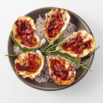 High Angle Still Life View of Plate of Oysters Kilpatrick Prepared with Bacon and Cheese and Served on with Salt on White Background