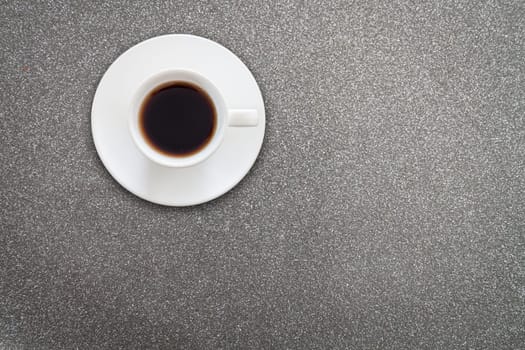 Close up white coffee cup on glitter black metallic texture background
